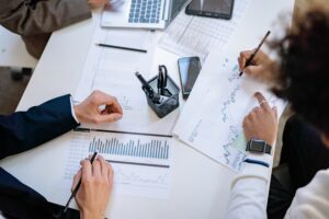 Business team analyzing financial charts and graphs during a collaborative meeting.